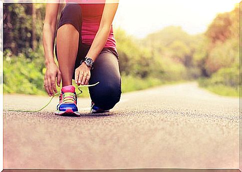 Woman tying a running shoe for a marathon