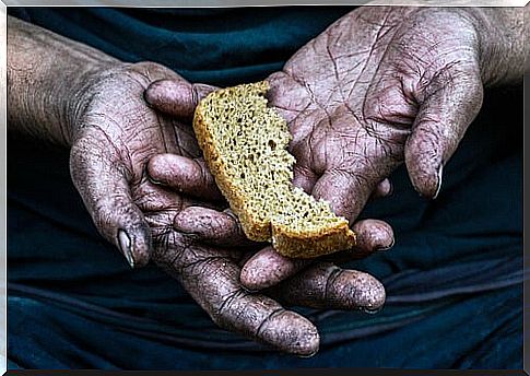 Hand with a piece of bread from a poor person