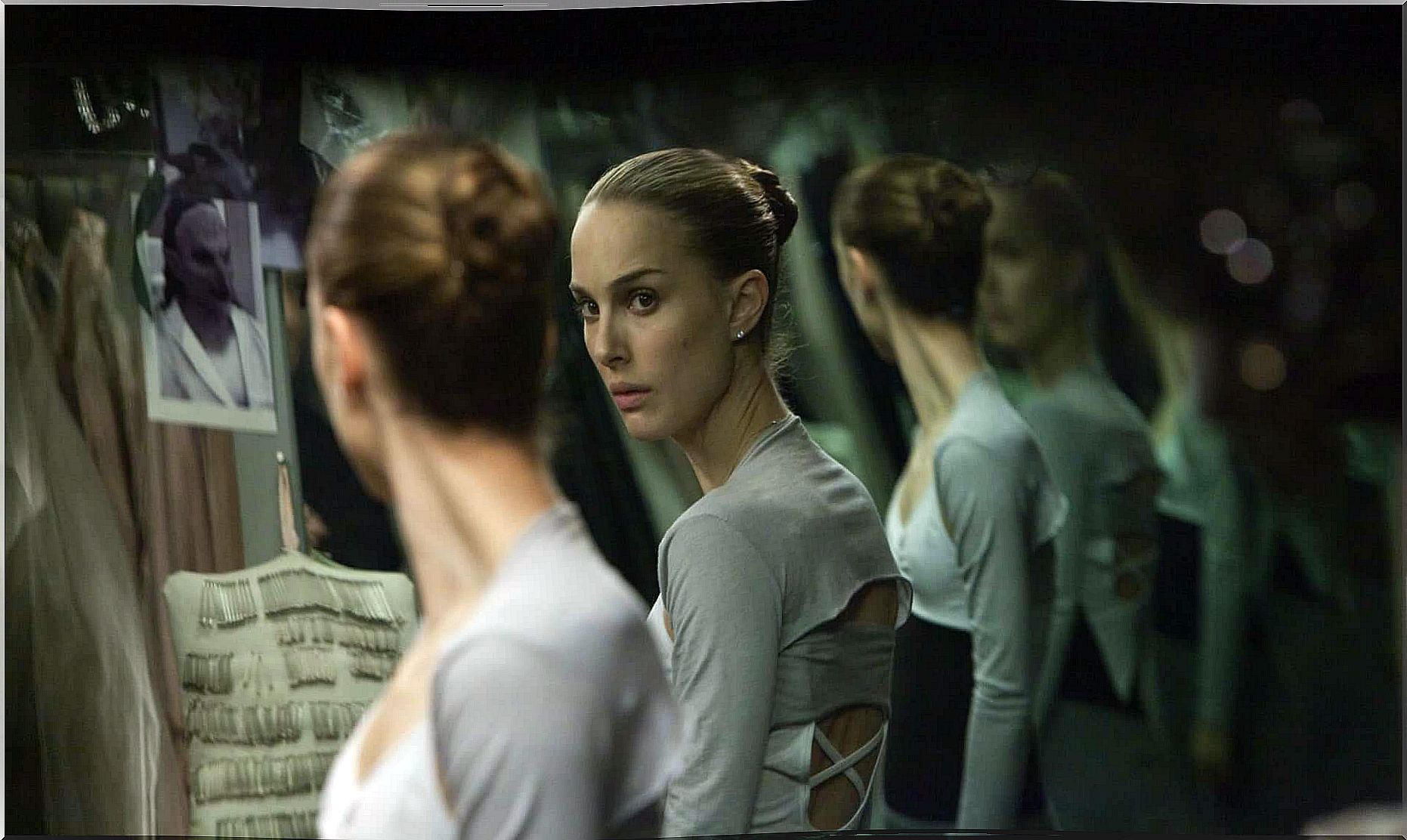 Dancer looking at herself in mirrors