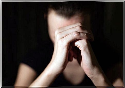 Woman with clasped hands asking for forgiveness