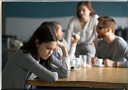 Woman away from her peers thinking that they are against her