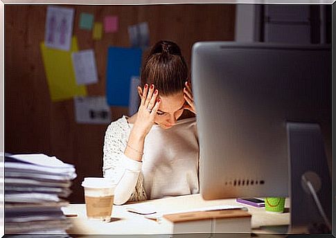 Tired woman sitting in front of her computer at work