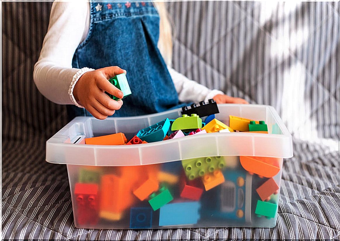 Little girl picking up toys