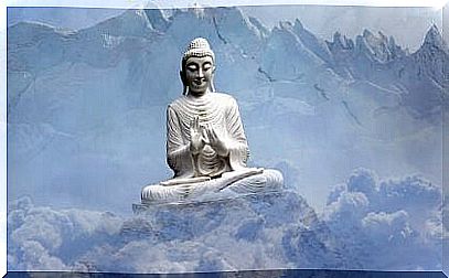 Buddha sculpture on a mountain surrounded by clouds