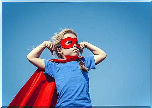 Boy dressed as a superhero with a red mask and cape