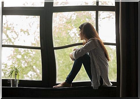 Sad woman sitting in a window