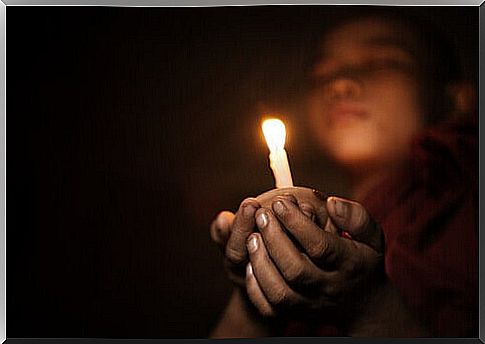 Buddhist boy with a candle meditating