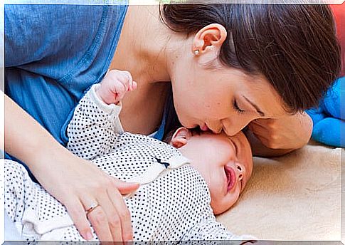 Mother stroking and kissing her baby