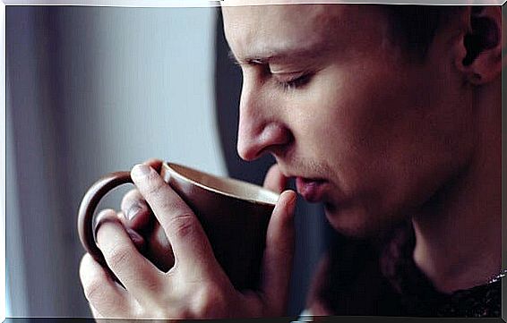 man with cup in hand enjoying the smell of coffee