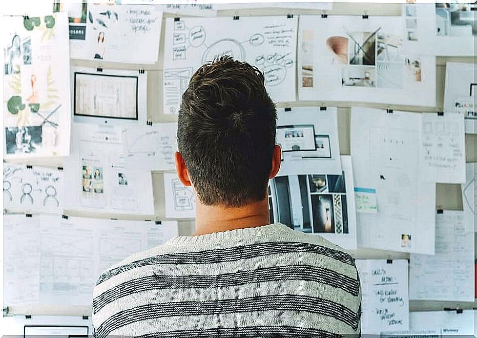 Man looking at papers on wall